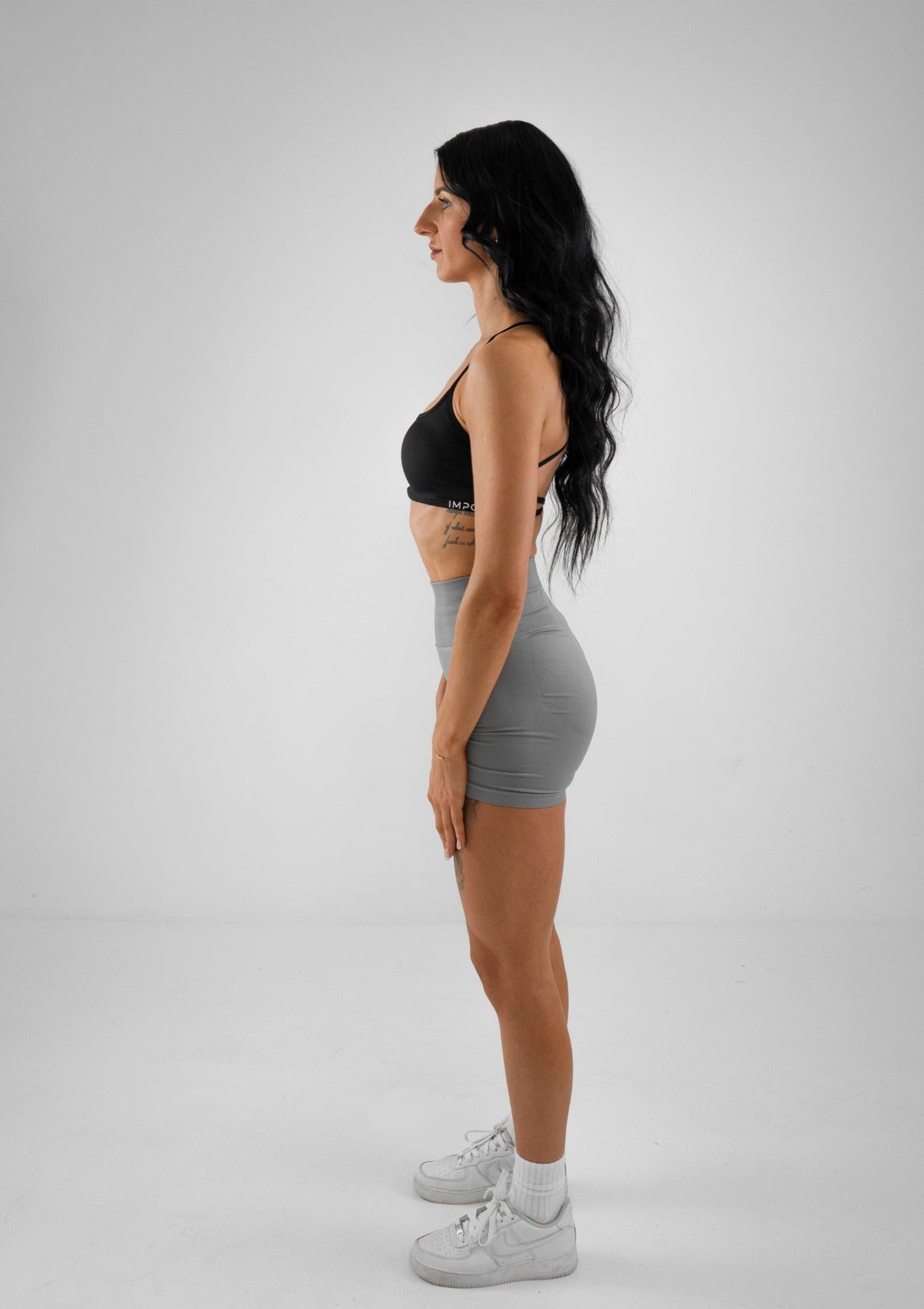 Model wearing grey activewear shorts and black bra set