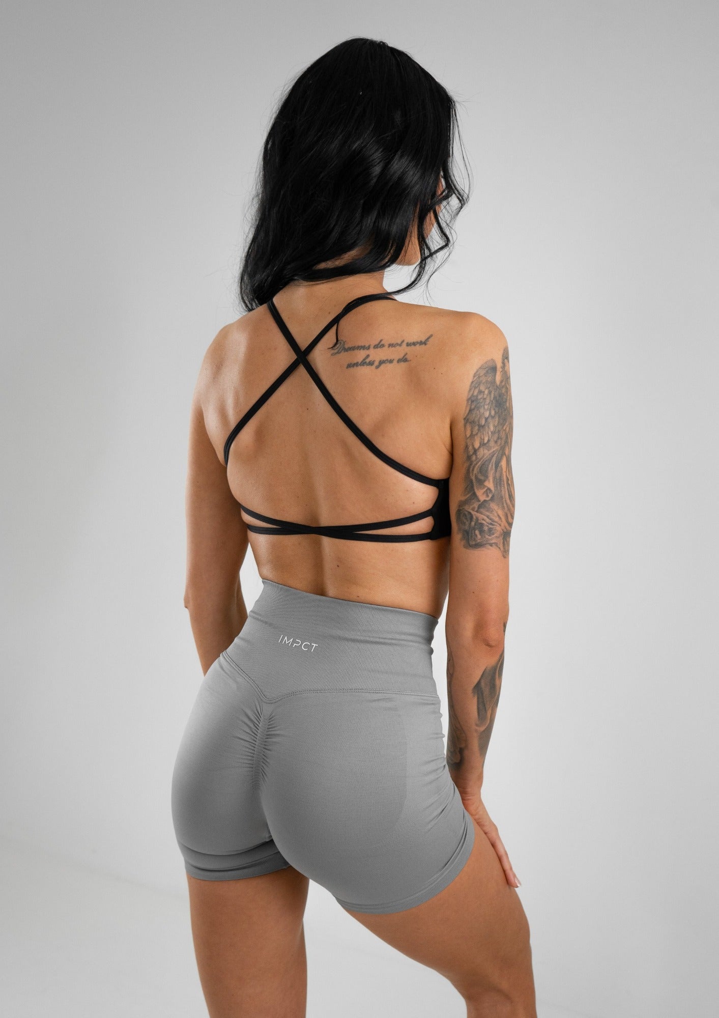 Model wearing grey activewear shorts and black bra set