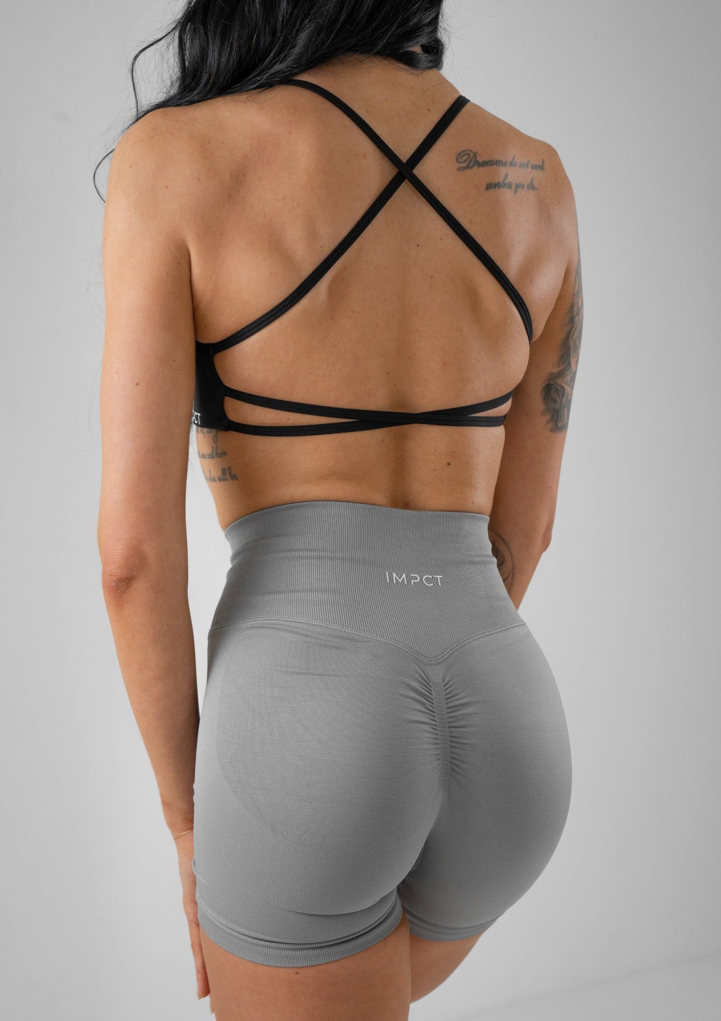 Model wearing grey activewear shorts and black bra set