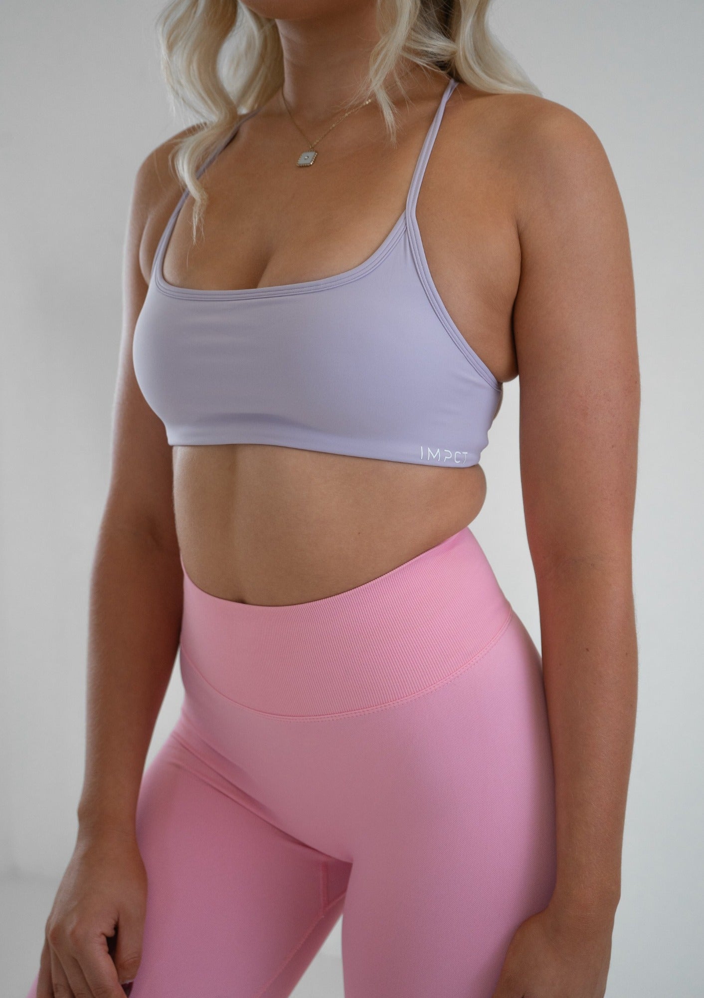 Model wearing a lilac activewear bra and pink leggings set