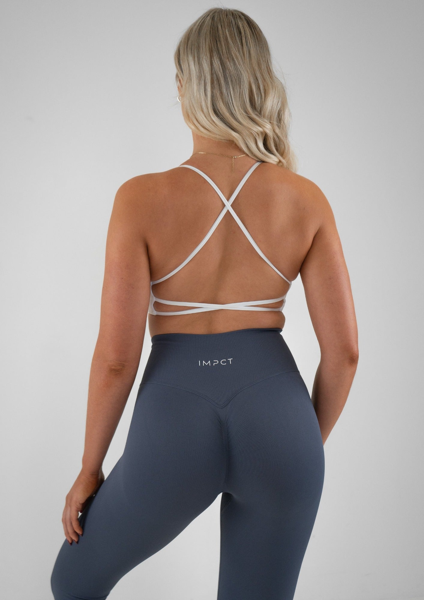 Model wearing blue colour activewear leggings and white bra set 