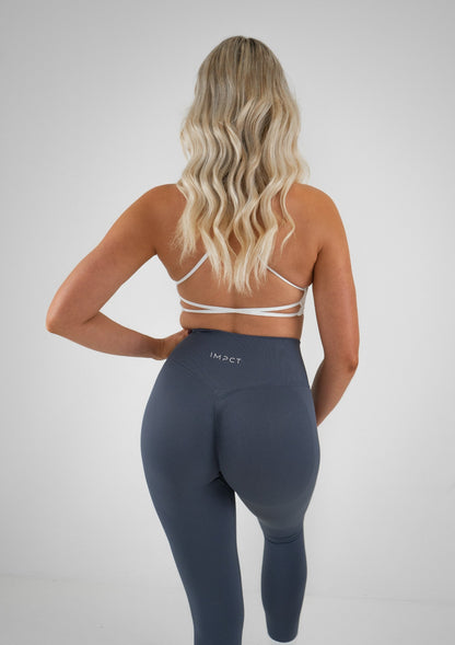 Model wearing blue colour activewear leggings and white bra set 