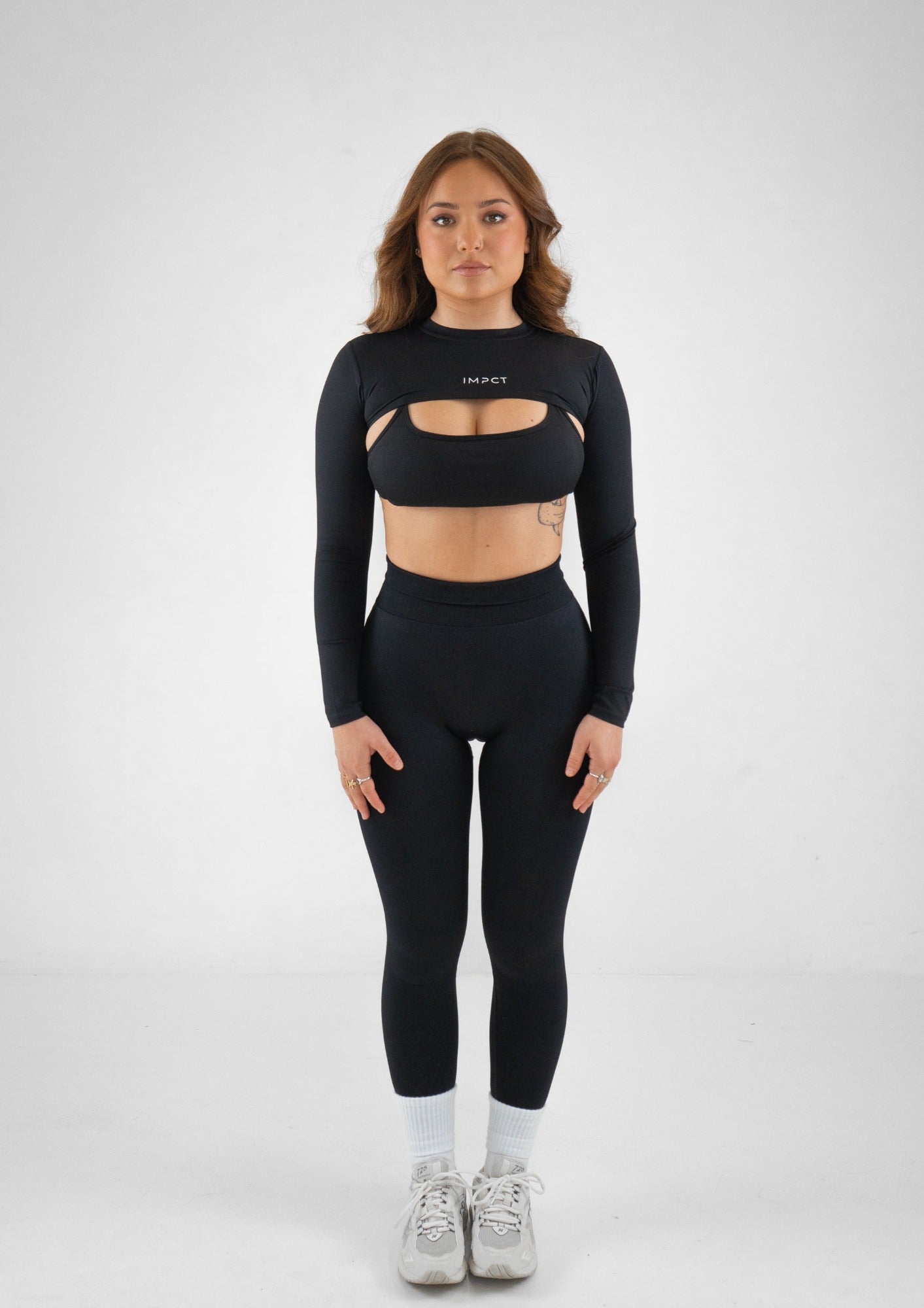 Model wearing black activewear set with black shrug