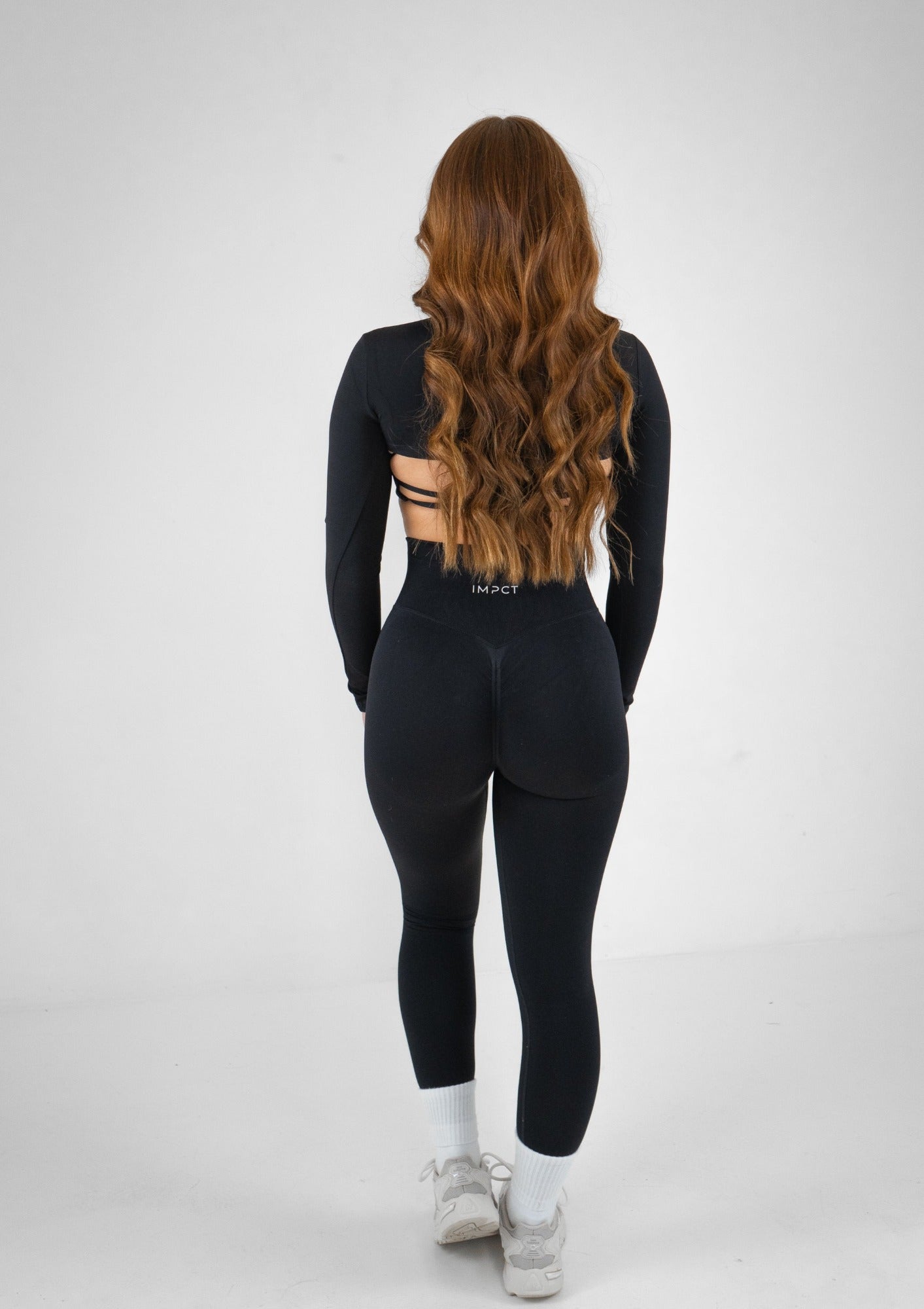 Model wearing black activewear set with black shrug