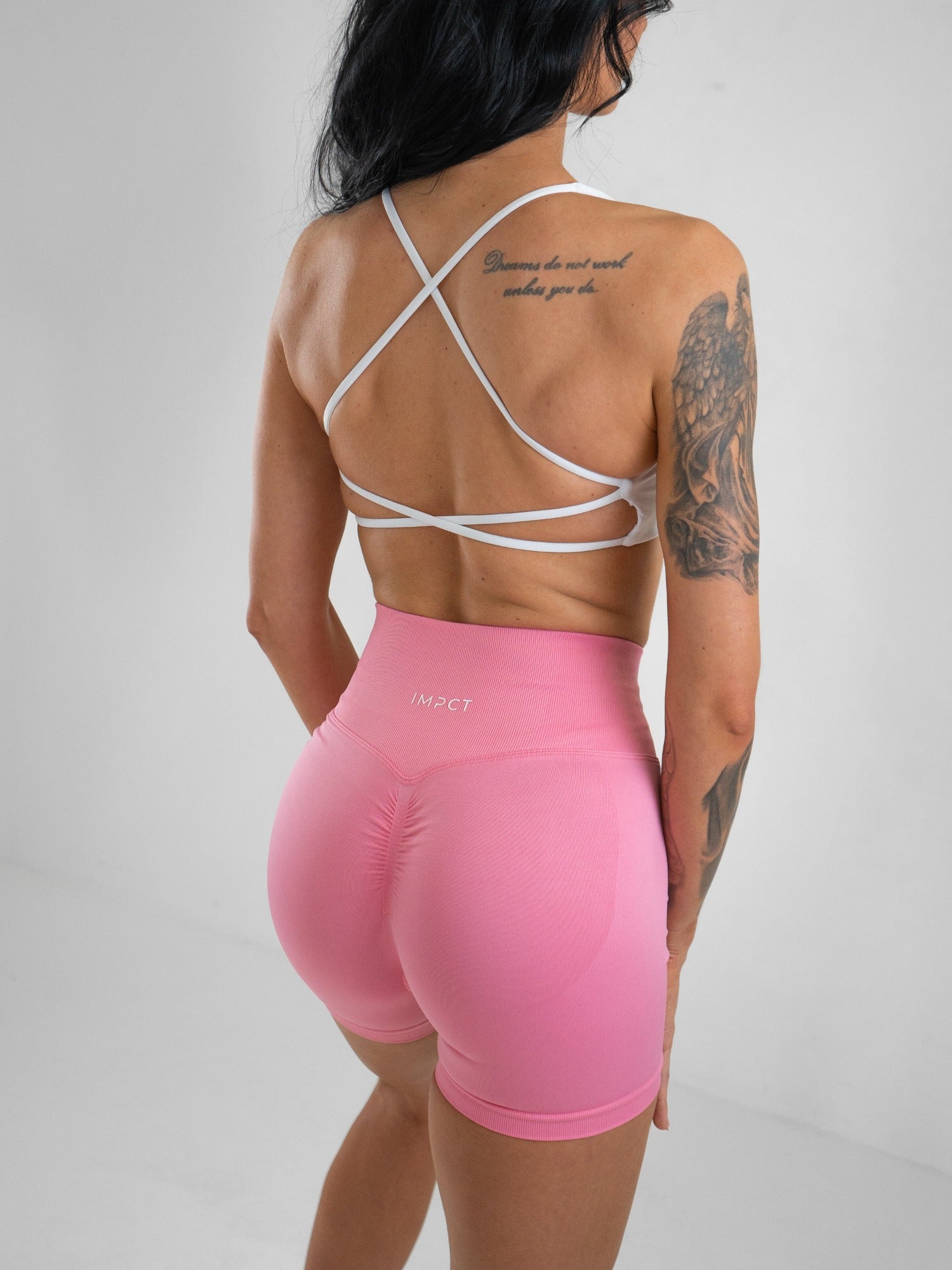 Model wearing a white activewear bra with pink shorts