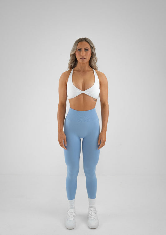 Model wearing blue colour activewear leggings and white bra set 