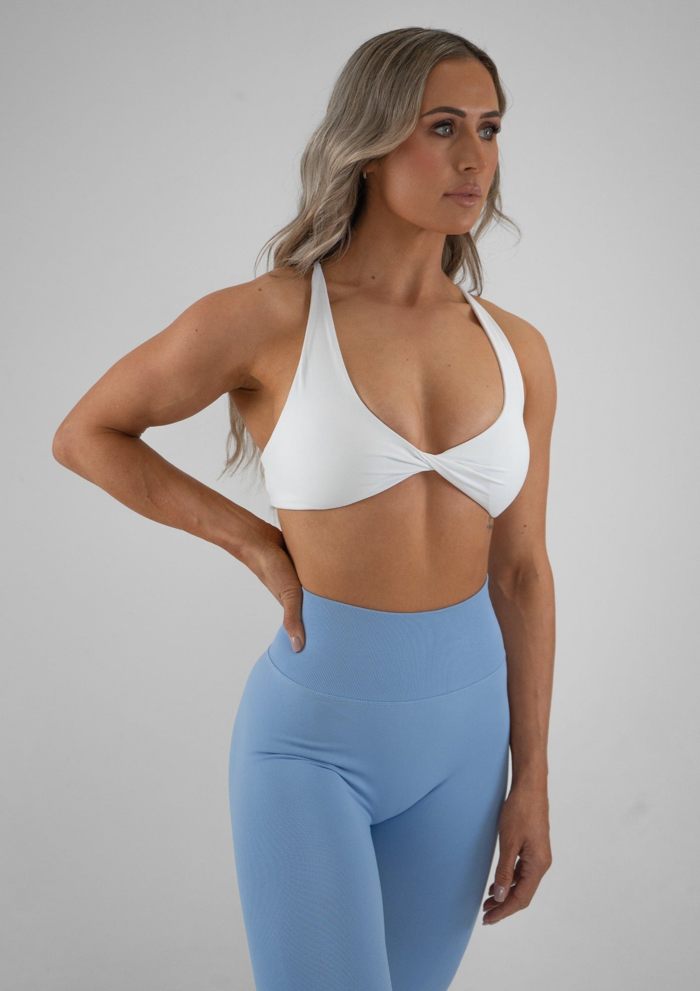 Model wearing a white activewear bra and light blue leggings set 