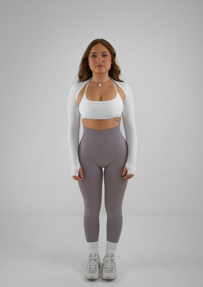 Model wearing thistle colour activewear leggings and white bra set with white bolero