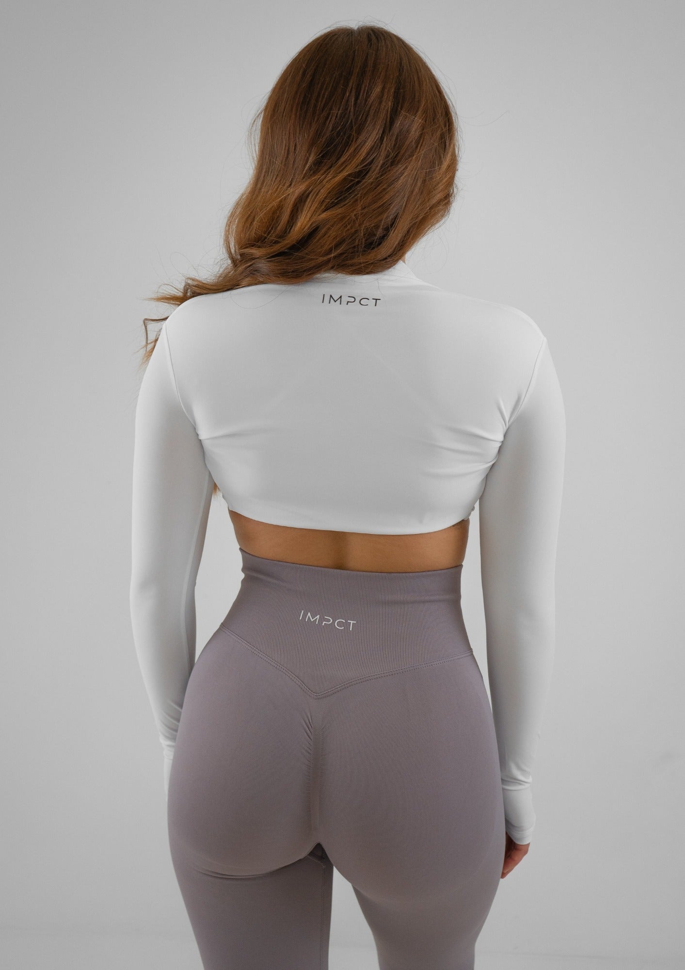 Model wearing thistle colour activewear leggings and white bra set with white bolero