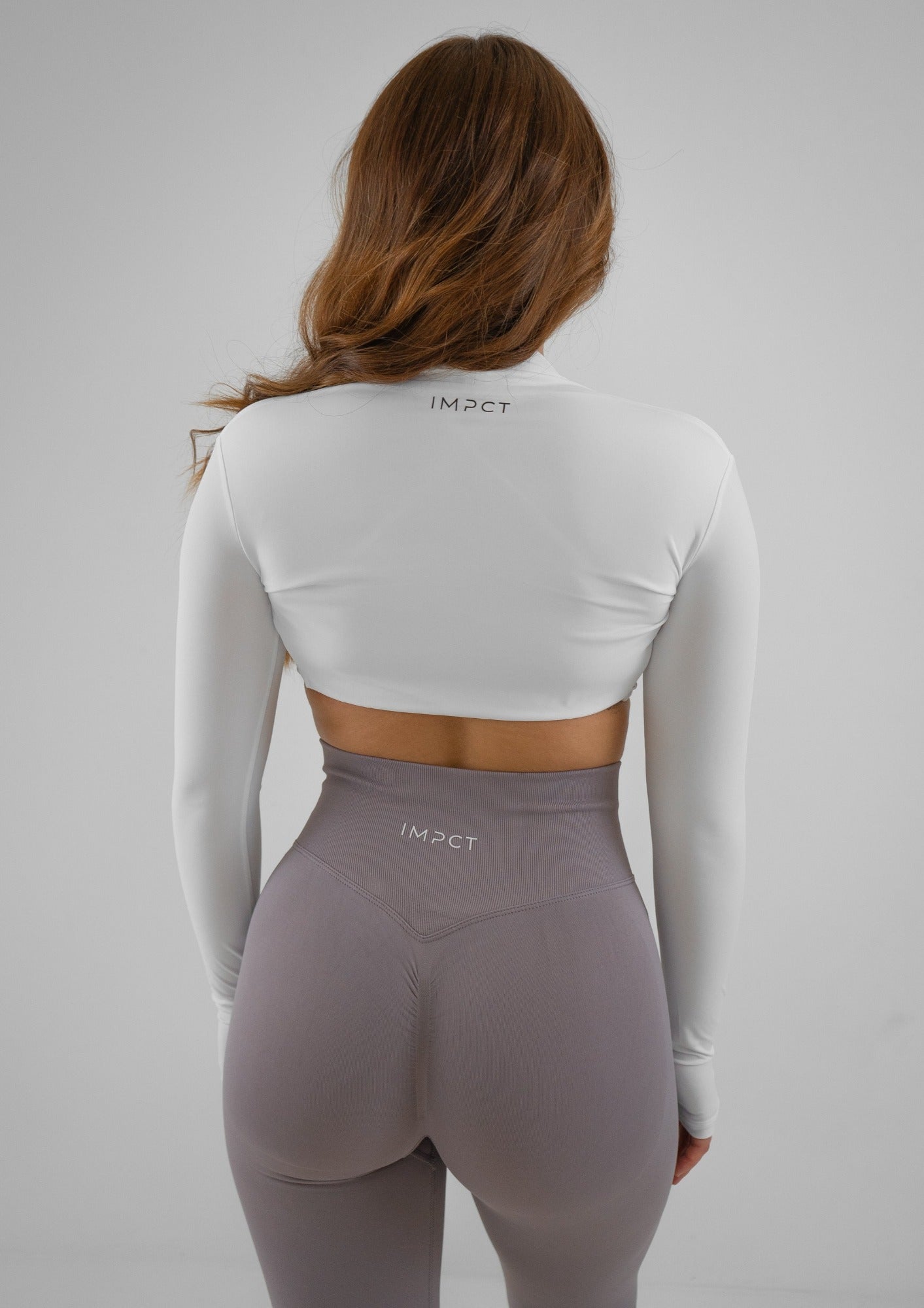 Model wearing a white activewear bolero and lilac leggings