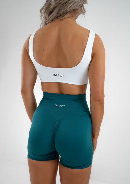 Model wearing a white activewear bra and green shorts set