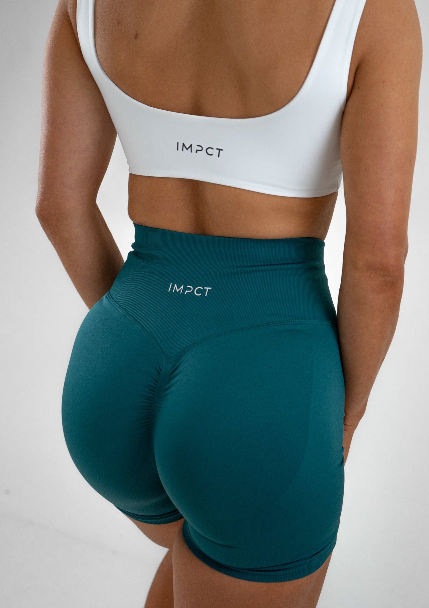 Model wearing a white activewear bra and green shorts set