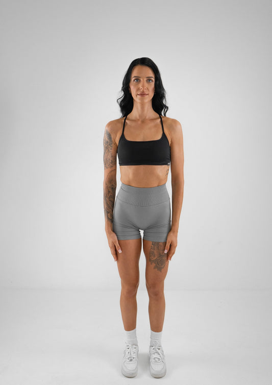 Model wearing grey activewear shorts and black bra set