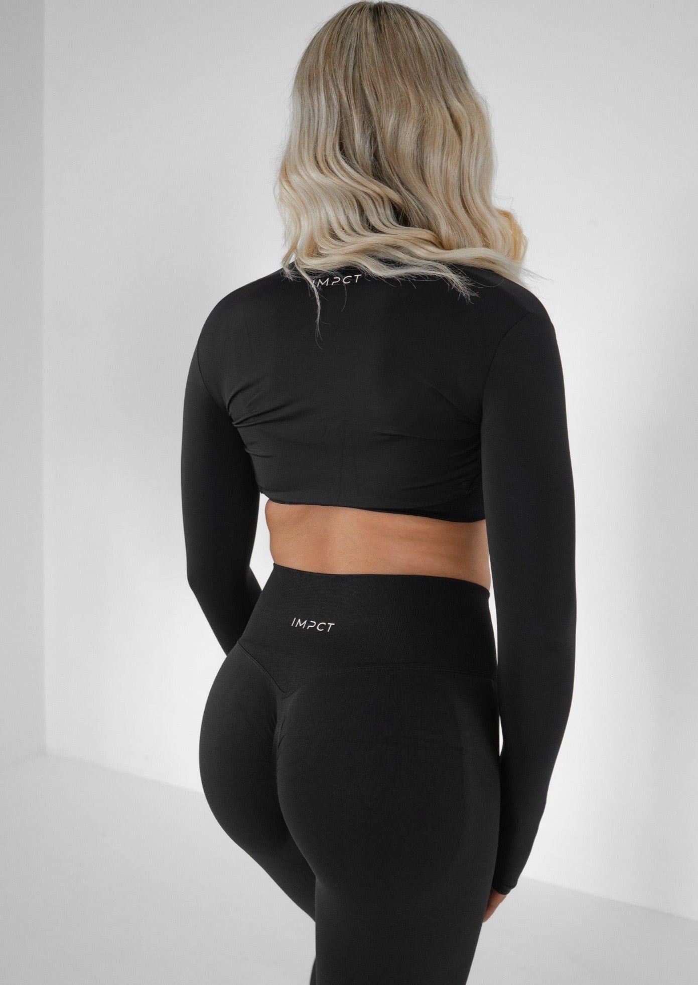 Model wearing a black activewear bolero and black set