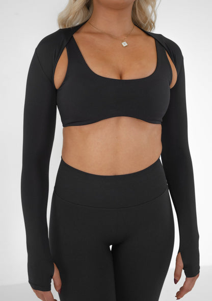 Model wearing a black activewear bolero and black set